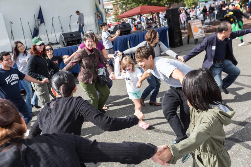 A group of people holding hands in a Korean ring dance