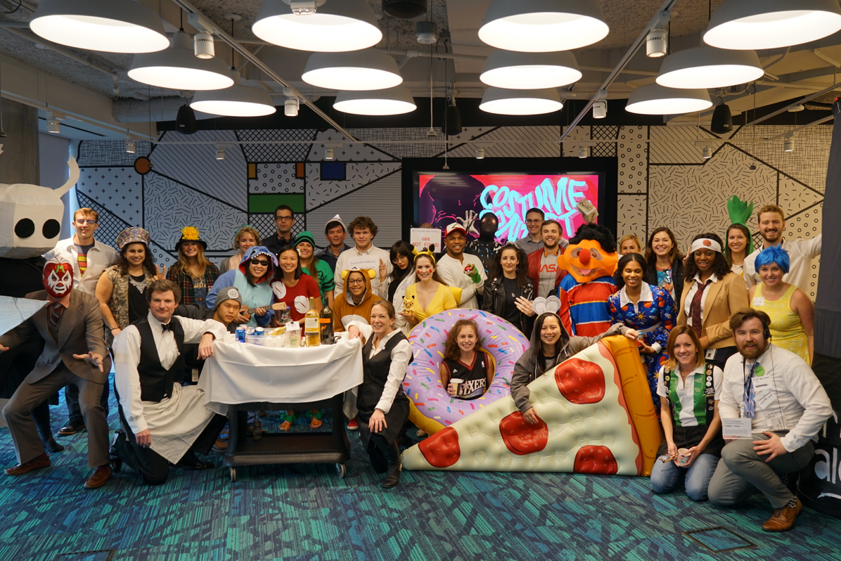 A group of Deloitte Employees in Halloween costumes smiling at the camera.