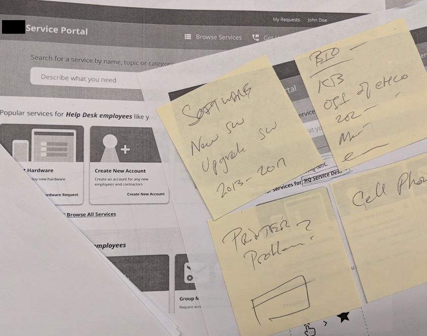 Four sticky notes with scribbled suggestions are placed above printed versions of the wireframes.